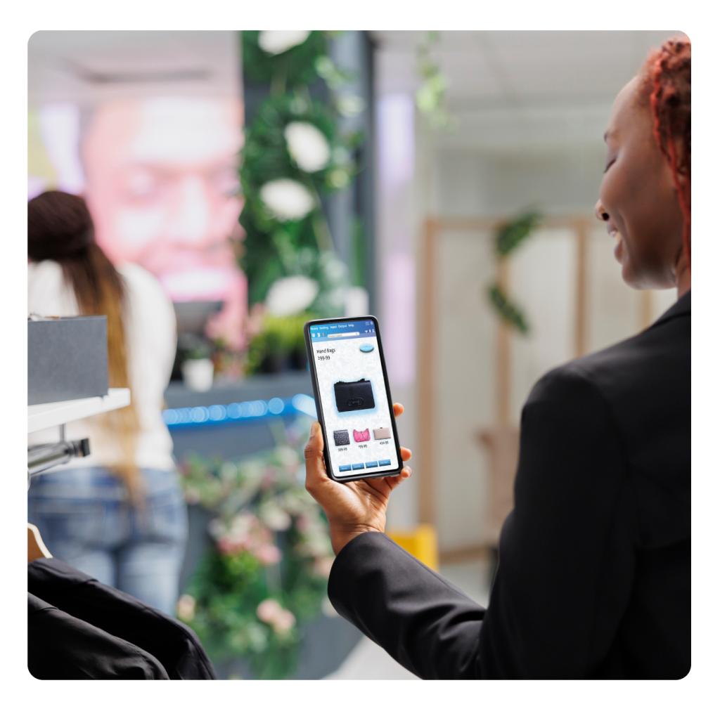 Femme tenant un smartphone dans une boutique pour comparer les prix et la vente omnicanal